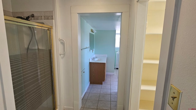 hall with radiator, sink, and light tile patterned flooring