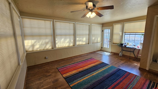 unfurnished sunroom featuring ceiling fan