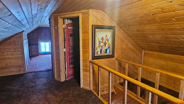 bonus room with dark carpet, vaulted ceiling, and wooden walls