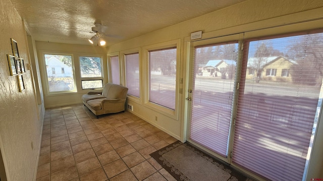 unfurnished sunroom featuring ceiling fan