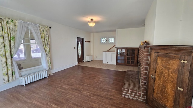 foyer with radiator heating unit and wood-type flooring