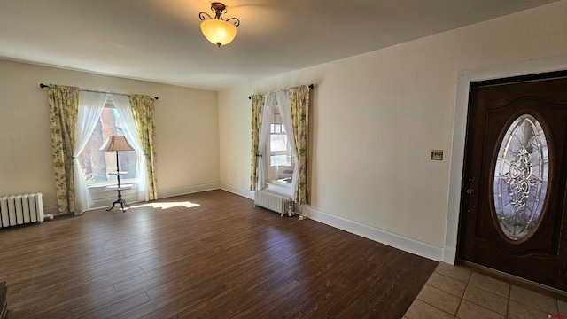 entrance foyer with radiator heating unit and hardwood / wood-style flooring