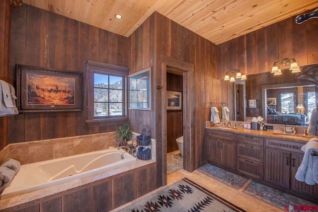 bathroom featuring a relaxing tiled tub, wood walls, toilet, vanity, and wood ceiling