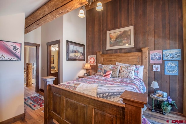 bedroom with wood walls and light hardwood / wood-style flooring