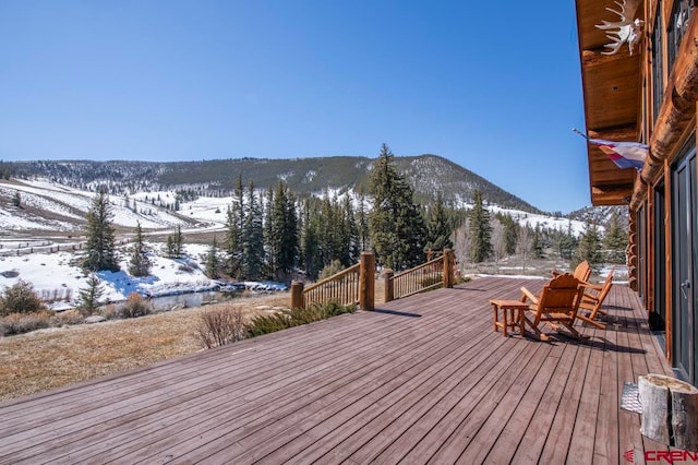 snow covered deck featuring a mountain view