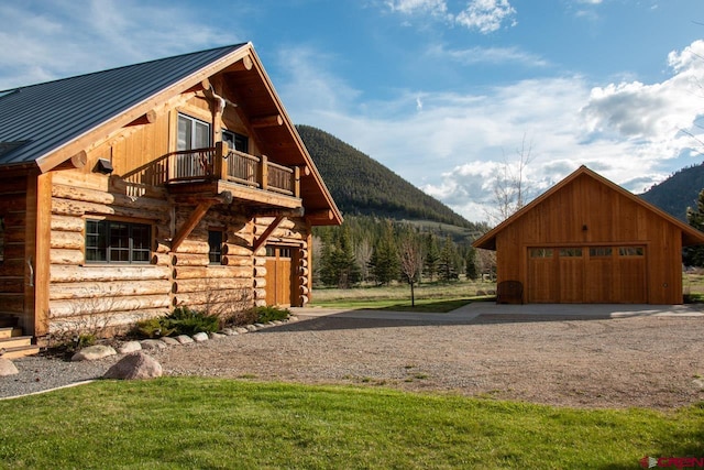 exterior space featuring a mountain view, a balcony, and an outbuilding