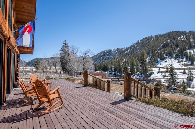 snow covered deck featuring a mountain view