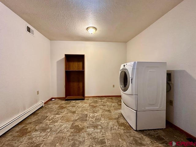 laundry room featuring a textured ceiling, tile floors, baseboard heating, and washer / clothes dryer