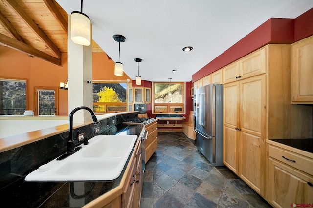 kitchen featuring lofted ceiling with beams, stainless steel appliances, sink, wood ceiling, and dark tile flooring