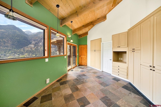 kitchen featuring decorative light fixtures, lofted ceiling with beams, wooden ceiling, a mountain view, and dark tile floors