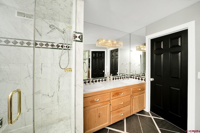 bathroom with tile flooring, double sink vanity, and an enclosed shower