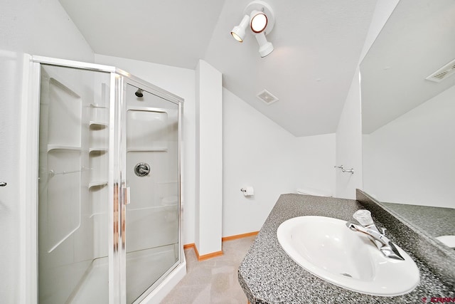 bathroom featuring a shower with door and vanity