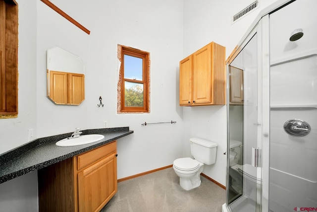 bathroom with vanity, toilet, and a shower with shower door