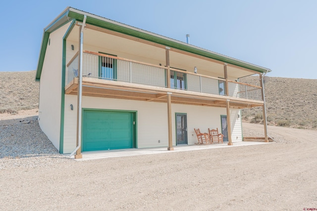 back of house with a garage and a balcony