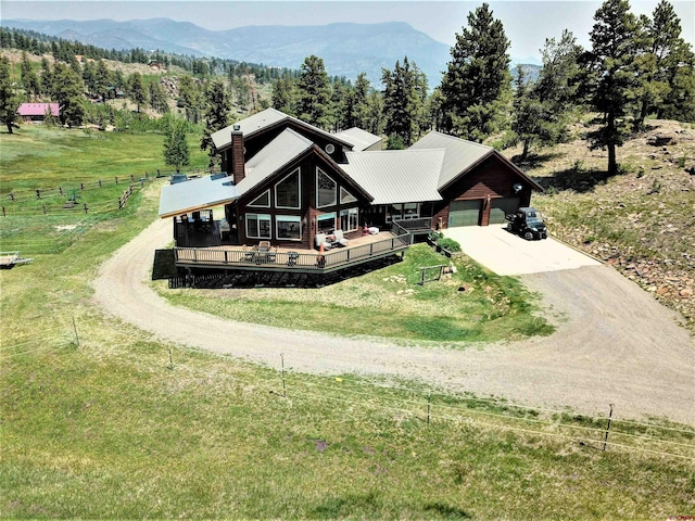 view of front of house with a rural view, a garage, and a deck with mountain view