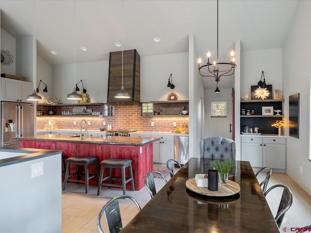 dining room featuring light hardwood / wood-style flooring, sink, and a notable chandelier