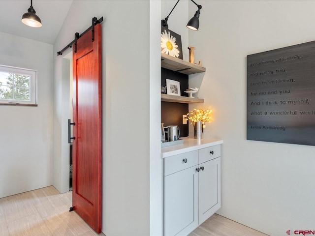 hall featuring vaulted ceiling and a barn door