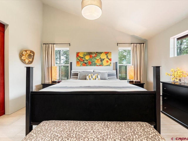 bedroom featuring lofted ceiling and multiple windows