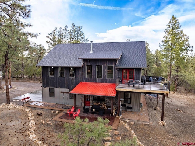 rear view of property featuring a deck and a patio