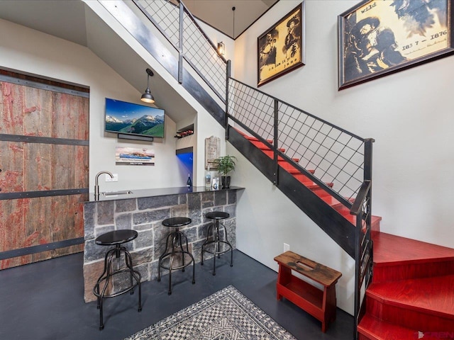 stairway with sink and a towering ceiling