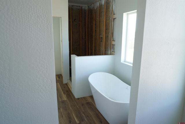 bathroom with a bath and wood-type flooring