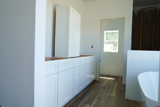 bathroom with vanity, hardwood / wood-style flooring, and a washtub