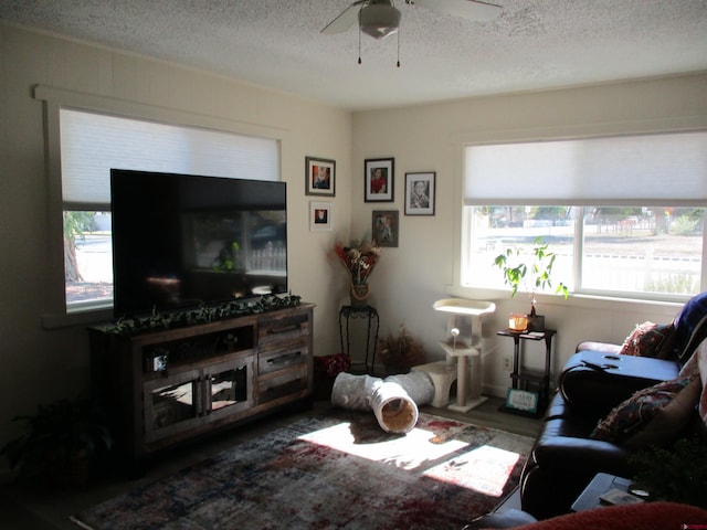 living room with a textured ceiling and ceiling fan