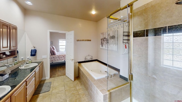 bathroom with tile flooring, shower with separate bathtub, and double sink vanity