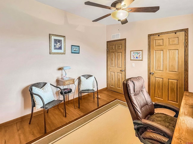 sitting room featuring hardwood / wood-style floors and ceiling fan