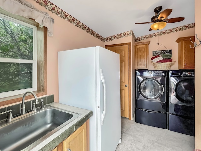 laundry area with independent washer and dryer, light tile floors, sink, cabinets, and ceiling fan