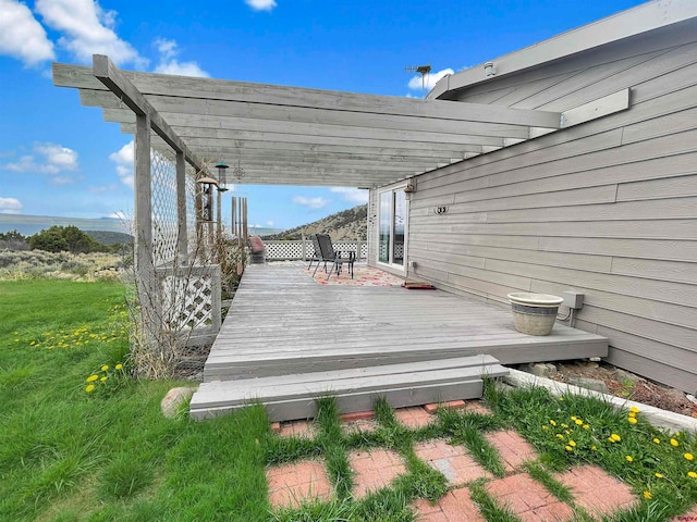 wooden terrace featuring a yard and a pergola