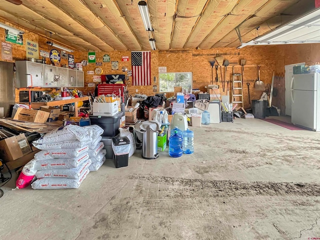 garage with a workshop area and stainless steel refrigerator