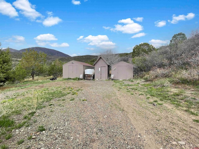 exterior space with a mountain view and a storage shed