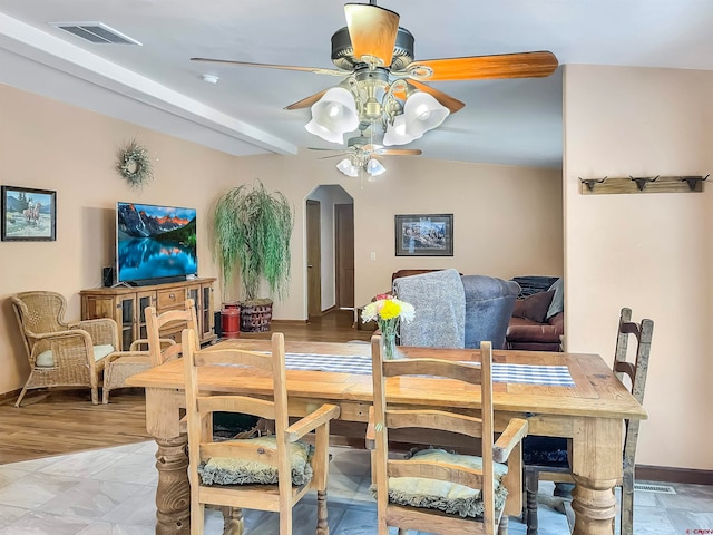 tiled dining space with beam ceiling and ceiling fan