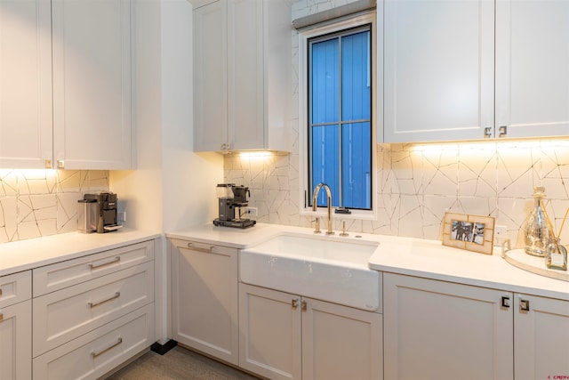 kitchen with sink, backsplash, and white cabinetry