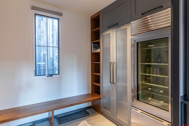 mudroom with beverage cooler and light tile floors