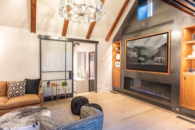 living room featuring light hardwood / wood-style floors, beamed ceiling, built in shelves, an inviting chandelier, and high vaulted ceiling