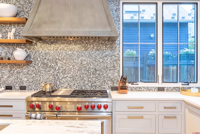 kitchen featuring double oven range, tasteful backsplash, and custom exhaust hood