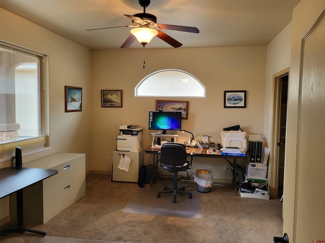 carpeted home office featuring ceiling fan