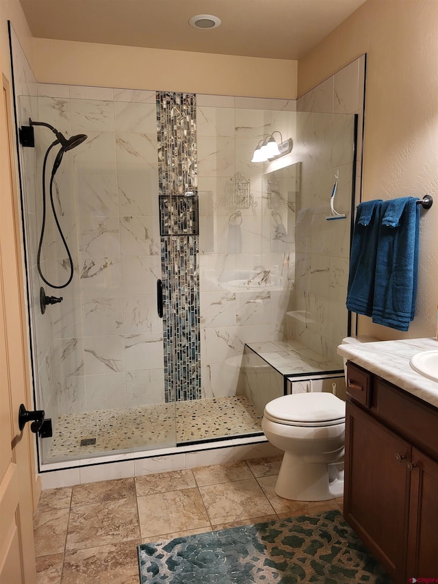 bathroom featuring vanity, toilet, and a shower with shower door