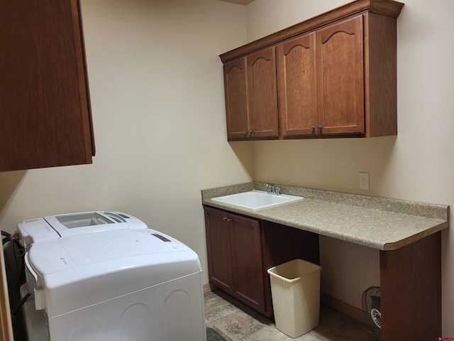 clothes washing area with sink, washer and dryer, and cabinets