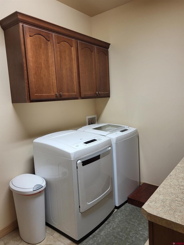 clothes washing area featuring washer and clothes dryer and cabinets