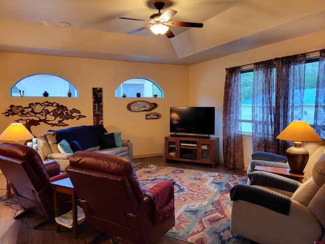 living room featuring ceiling fan, hardwood / wood-style flooring, and a tray ceiling