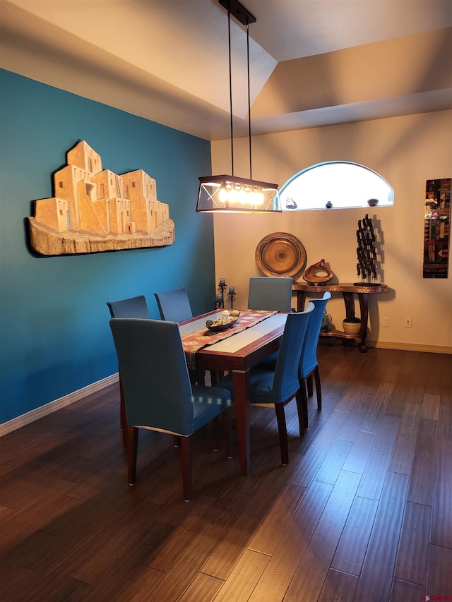 dining room with dark wood-type flooring and vaulted ceiling