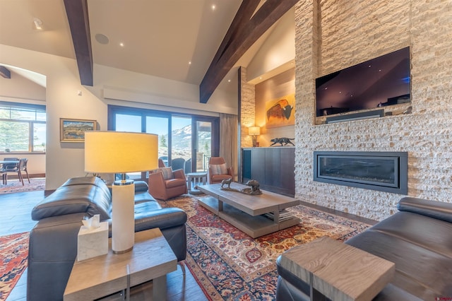 living room with beam ceiling, a healthy amount of sunlight, high vaulted ceiling, and a fireplace