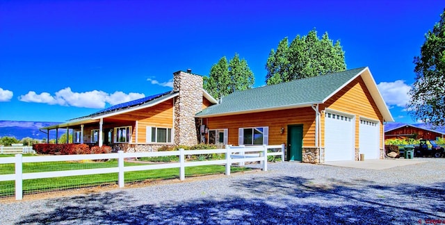 log-style house with a garage and an outdoor structure