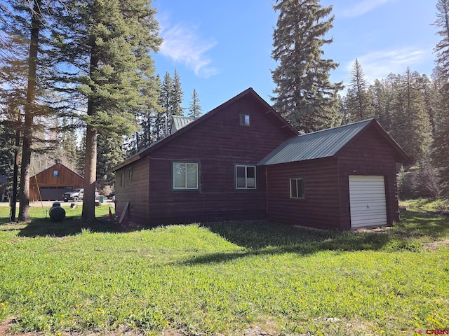 view of property exterior with an outdoor structure, a garage, and a yard