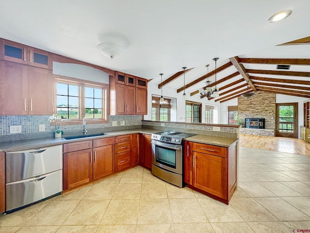 kitchen with decorative light fixtures, vaulted ceiling with beams, a stone fireplace, sink, and appliances with stainless steel finishes