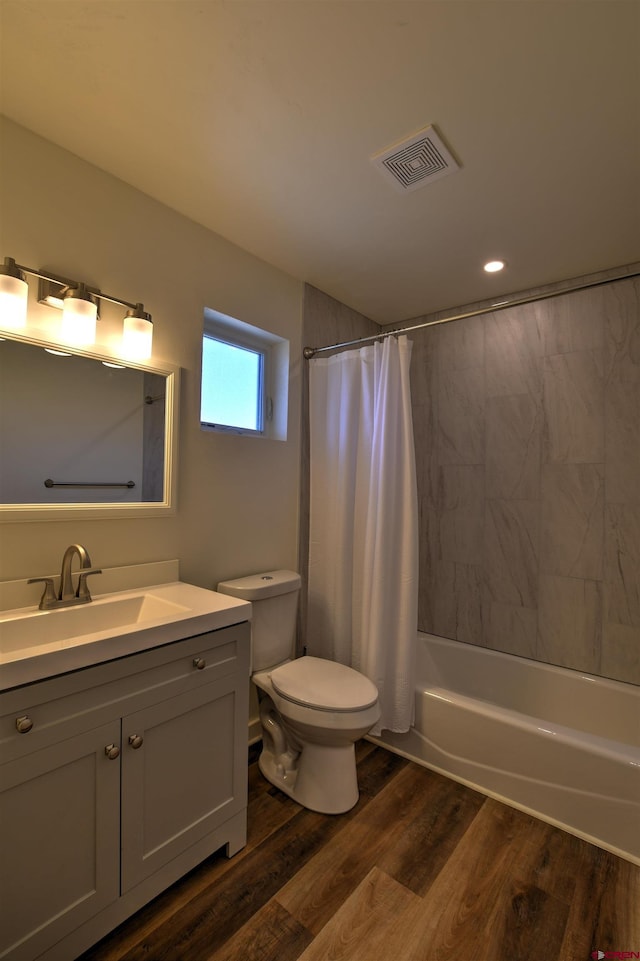 full bathroom with visible vents, shower / bathtub combination with curtain, toilet, vanity, and wood finished floors