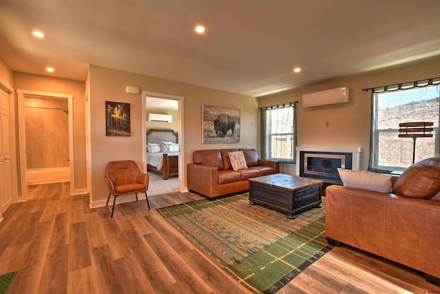 living room featuring a wall mounted air conditioner, wood finished floors, and recessed lighting